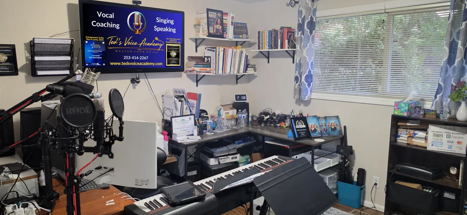 Ted Chamberlain's voice studio in Lacey, with a keyboard, studio microphones and bookshelves of music