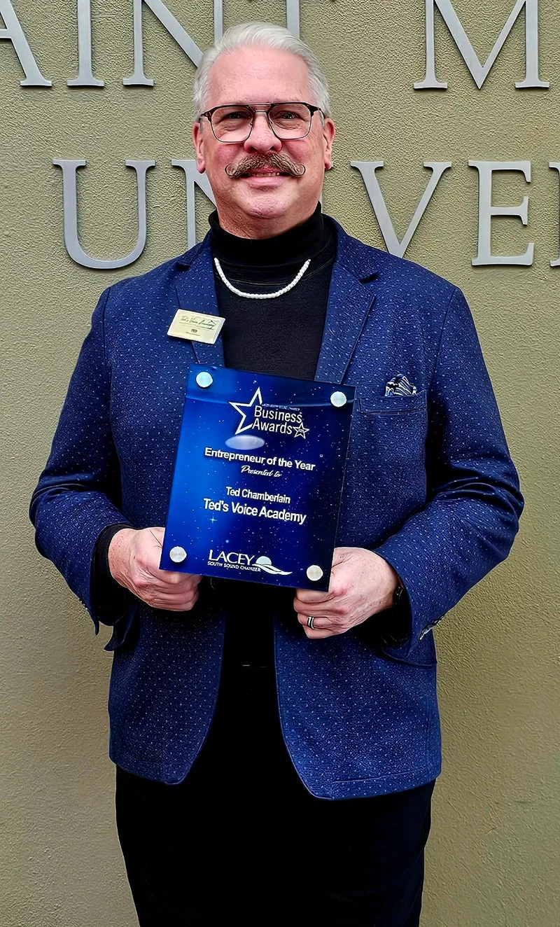 Ted Chamberlain holding Entrepreneur of the Year award plaque at Saint Martin's University